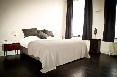 a white bedroom with a bed with a white blanket at House Ninety Guesthouse in Brussels