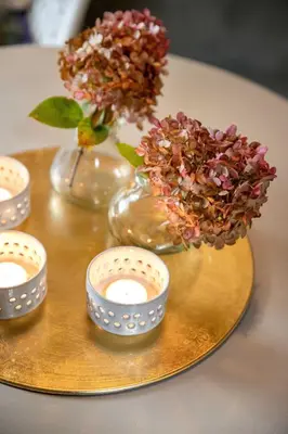 a gold tray with candles and flowers on a table at Het Verblijf in Sint-Martens-Lennik