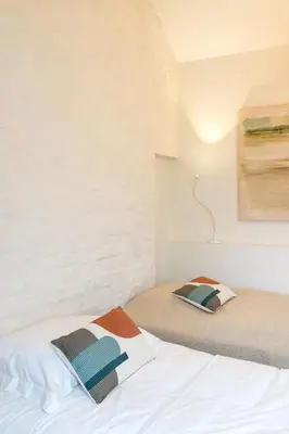 a bedroom with two beds and a painting on the wall at Het Verblijf in Sint-Martens-Lennik