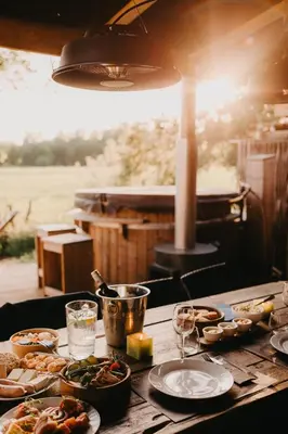 a wooden table with plates of food on it at AMANI - Aap in Lichtaart