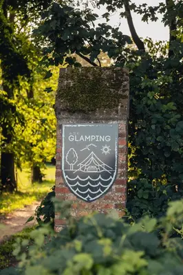 a sign for a clambering on a brick wall at AMANI - Aap in Lichtaart