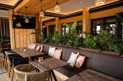 a restaurant with wooden walls and tables and plants at ASILI DELUXE - Zebra in Lichtaart