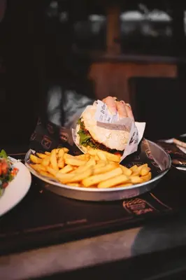 a plate with a sandwich and french fries on a table at POLE POLE - Ijsbeer in Lichtaart