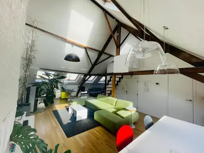 a living room with a green couch and a table at Spacious Loft in the Historical Centre in Ghent