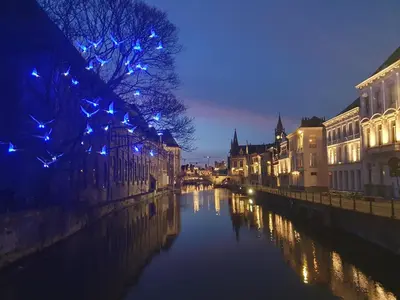 a canal in a city at night with lights at Spacious Loft in the Historical Centre in Ghent