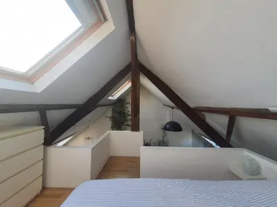 a attic bedroom with a bed and a window at Spacious Loft in the Historical Centre in Ghent