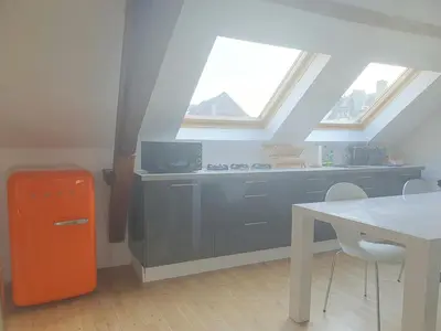 an attic kitchen with an orange refrigerator and a table at Spacious Loft in the Historical Centre in Ghent