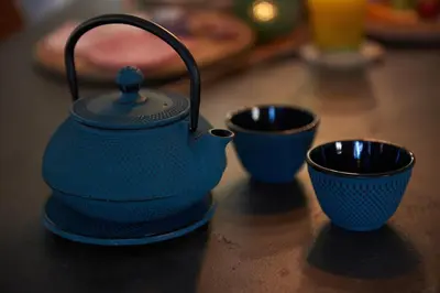 a blue tea kettle and two cups on a table at B&B Pura Vista in Zandhoven