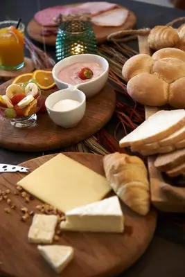 a table topped with cheese and bread on plates at B&B Pura Vista in Zandhoven