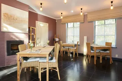 a dining room with tables and chairs and a fireplace at B&B Zinnen en Minnen in Herselt
