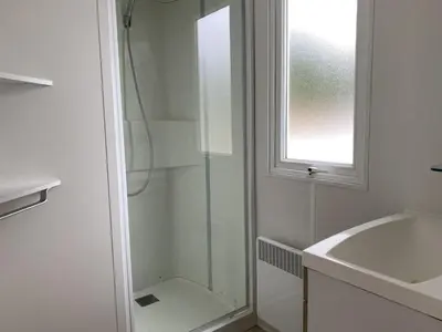 a bathroom with a shower and a sink and a window at Chalet near Antwerp with Pool Access in Rijkevorsel