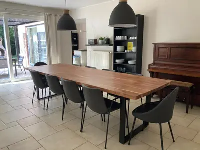 a dining room table with chairs and a piano at Hammo in Ham