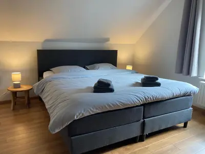 a bedroom with a large bed with two black towels on it at Hammo in Ham