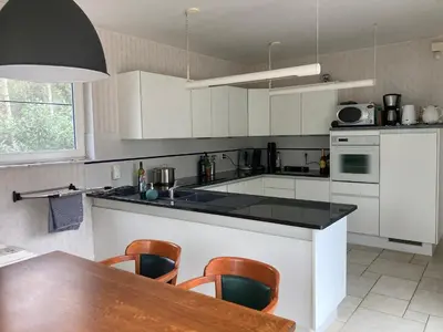 a kitchen with white cabinets and a table and chairs at Hammo in Ham