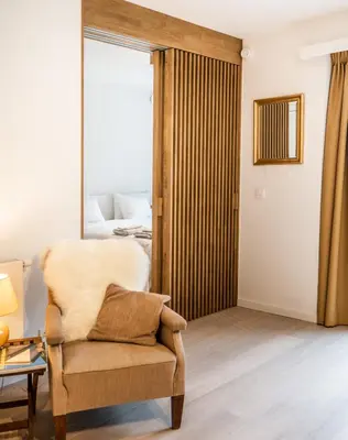 a living room with a chair and a bed at La Vista in Tervuren