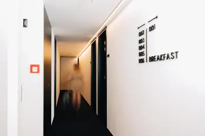 a person walking down a hallway with a sign on the wall at Factory Hotel in Beveren