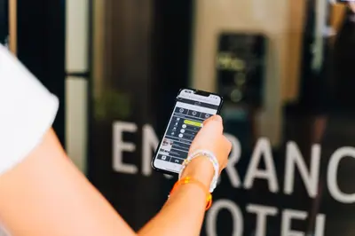 a person holding a cell phone in their hand at Factory Hotel in Beveren