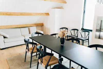 a room with tables and chairs and a couch at Factory Hotel in Beveren