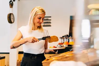 a woman is preparing food in a kitchen at Factory Hotel in Beveren