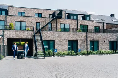 two people standing in front of a brick building at Factory Hotel in Beveren