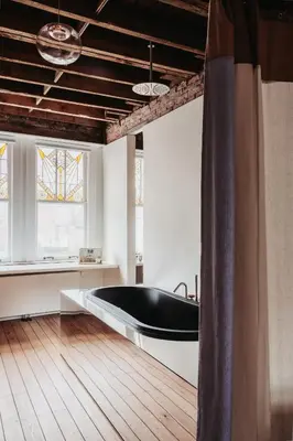a bathroom with a black bath tub in a room at Huis Hector Mechiels ROOM in Sint-Niklaas