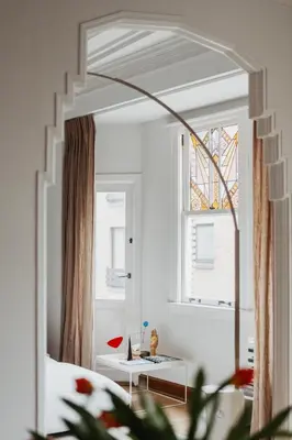 a mirror in a room with a table and a window at Huis Hector Mechiels ROOM in Sint-Niklaas
