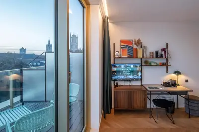 a room with a desk with a computer and a balcony at Yalo Urban Boutique Hotel Gent in Ghent