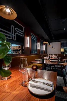 a restaurant with a wooden table with wine glasses at Yalo Urban Boutique Hotel Gent in Ghent