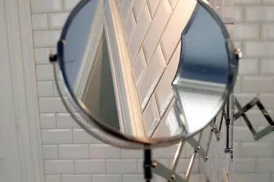 a mirror hanging on a wall in a bathroom at Atlas B&B in Ghent
