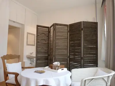 a room with a table and some wooden shutters at B&B Sparrow's Nest in Ghent