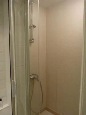 a shower with a glass door in a bathroom at B&B Sparrow's Nest in Ghent