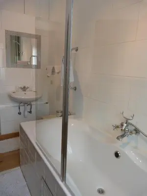a white bathroom with a tub and a sink at B&B Sparrow's Nest in Ghent