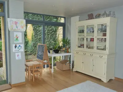 a living room with a large white cabinet and a table at B&B Sparrow's Nest in Ghent
