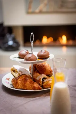 two plates of pastries on a table with a glass of milk at Adamas B&B in Dendermonde