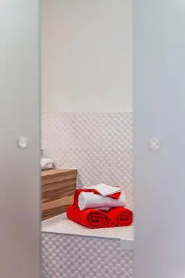 a bedroom with a bed with red and white towels at Adamas B&B in Dendermonde