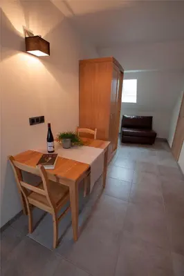 a dining room with a wooden table and a couch at B&B D'Hollehoeve in Heist-op-den-Berg