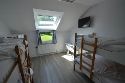 a dorm room with two bunk beds and a desk at Auberge des 3 Fontaines - Youth Hostel in Brussels