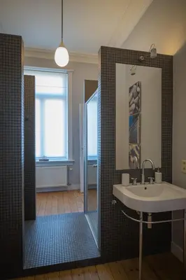 a bathroom with a sink and a shower with a mirror at Garden of Eden in Antwerp