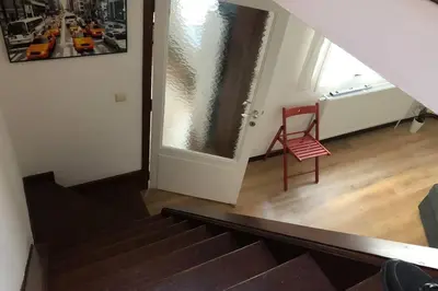a stairway with a red chair and a window at Easy comfort in Brussels