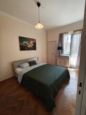 a bedroom with a large bed with a green blanket at Belga Apartment 3 bedrooms. in Antwerp