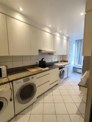 a kitchen with white cabinets and washing machines at Belga Apartment 3 bedrooms. in Antwerp