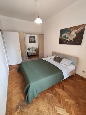 a bedroom with a large bed with a green blanket at Belga Apartment 3 bedrooms. in Antwerp