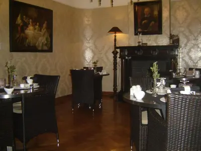 a dining room with tables and chairs and a fireplace at B&B The Baron in Antwerp