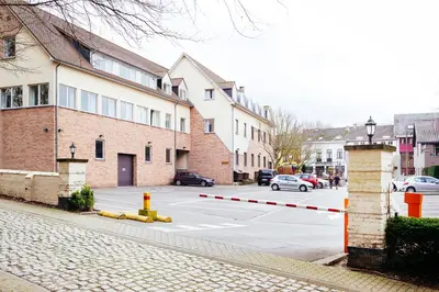 a street with a parking lot with cars and buildings at Hotel Soret in Overijse