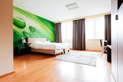 a bedroom with a bed and a green wall at Hotel Soret in Overijse