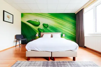 a bedroom with a bed and a green wall at Hotel Soret in Overijse