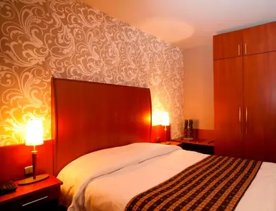 a bedroom with a large bed and two lamps at Hotel De Notelaer in Bornem