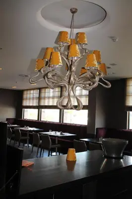a chandelier in a restaurant with tables and chairs at Hotel De Notelaer in Bornem