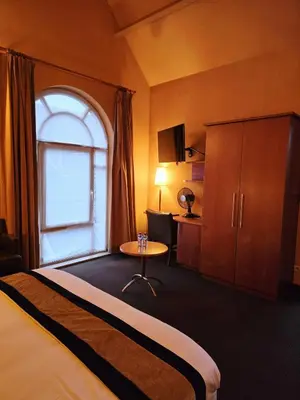 a hotel room with a bed and a window at Hotel De Notelaer in Bornem