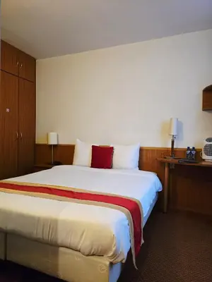 a hotel room with a large white bed with red pillows at Hotel De Notelaer in Bornem